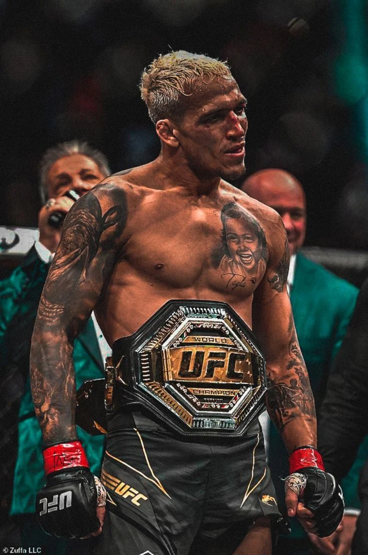A mixed martial arts fighter wearing a UFC championship belt inside the octagon.